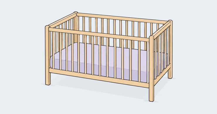 Empty wooden cot with a fitted mattress and no loose bedding